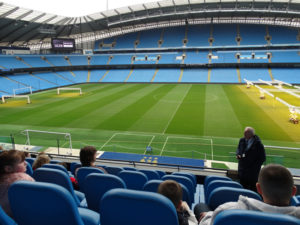 In the primo seats with the best view of Etihad Stadium.